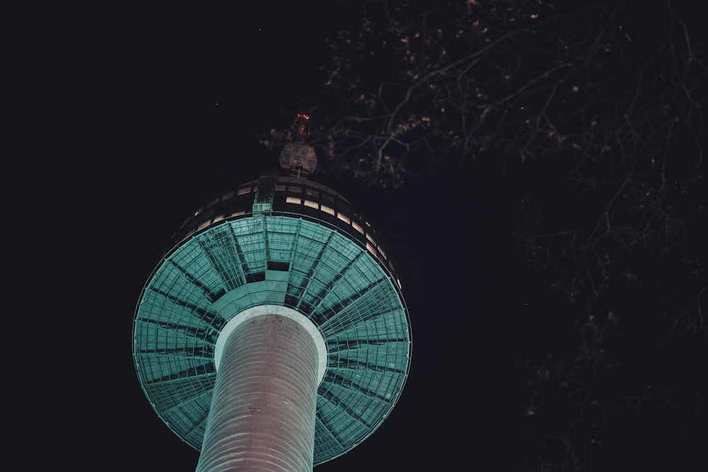 the top of a tall tower lit up at night