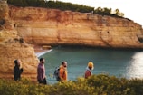 Group of friends hiking along a scenic coastal trail with clear blue skies