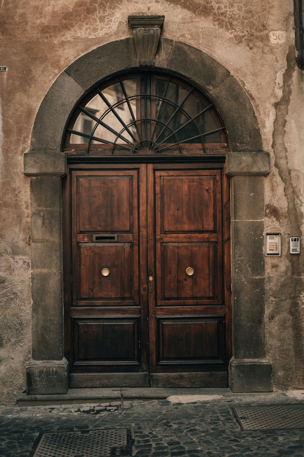 Un par de puertas de madera sentadas en el costado de un edificio