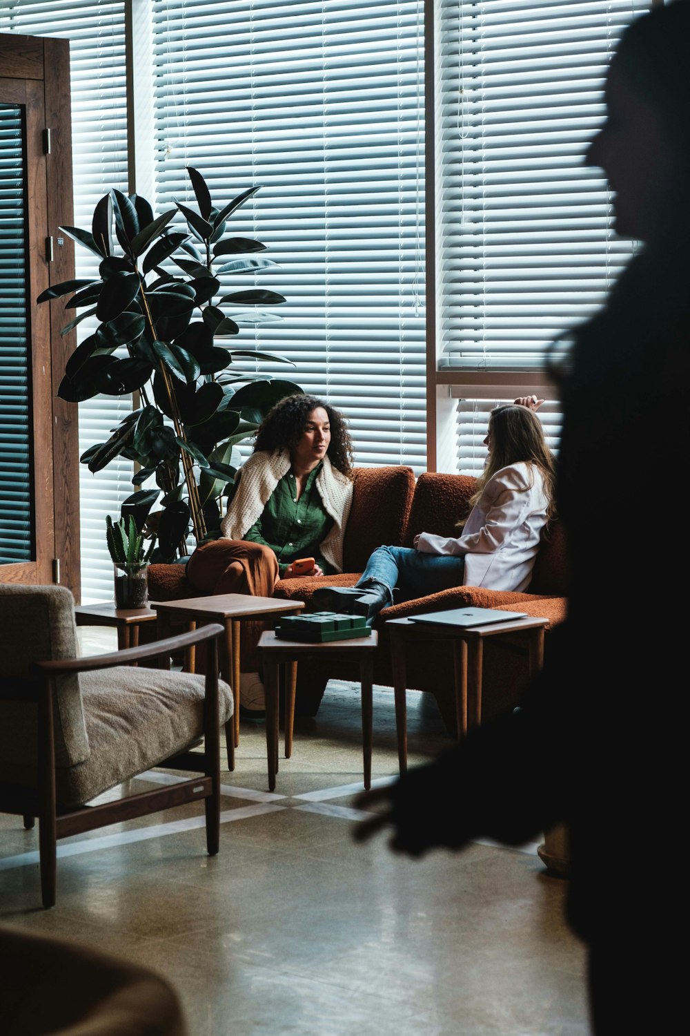 two women sitting on a couch in a living room