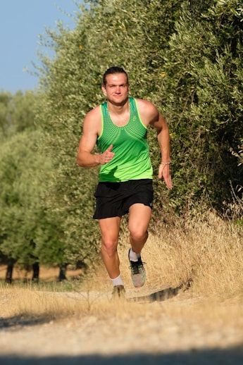 a man in a green shirt and black shorts running