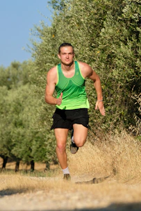 Energetic man running outdoors at sunrise, representing vitality and energy.