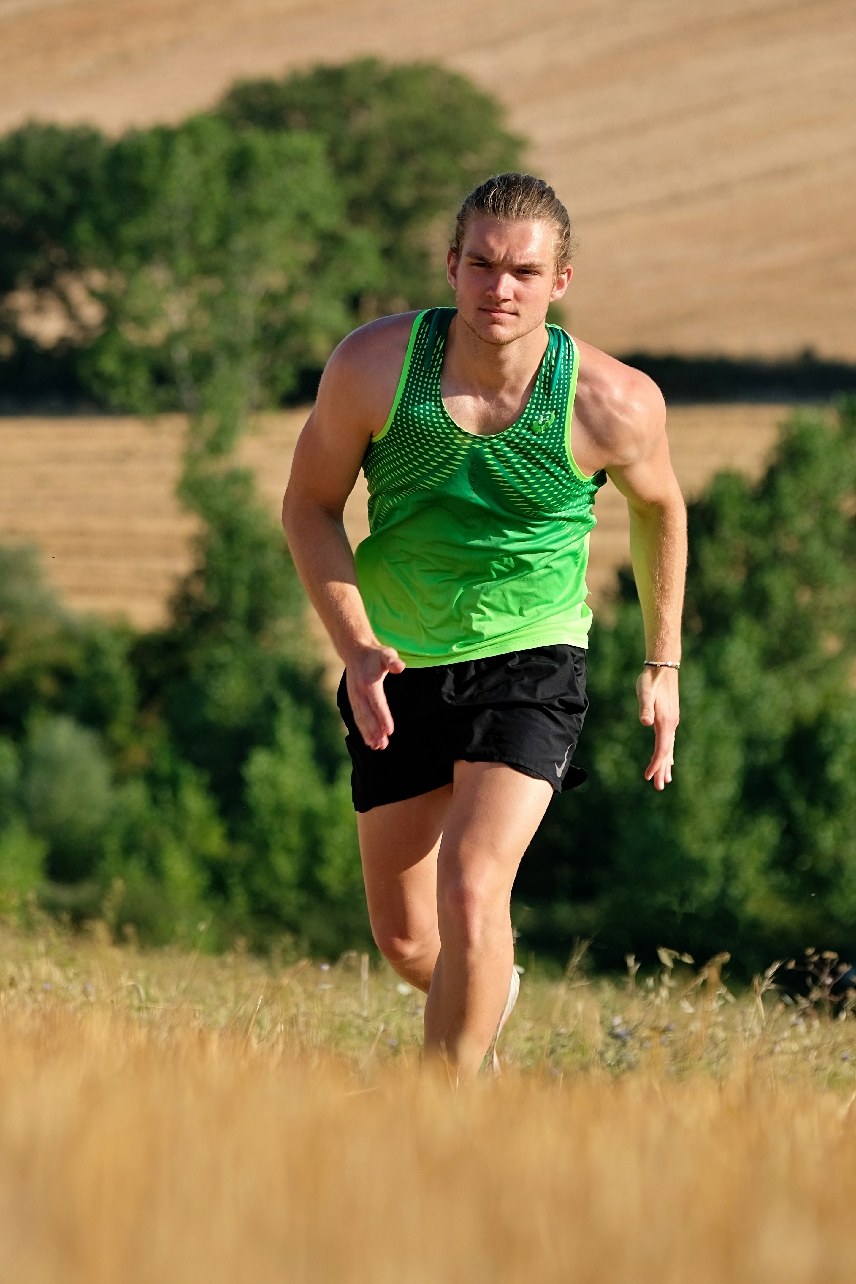 a man running through a field of tall grass