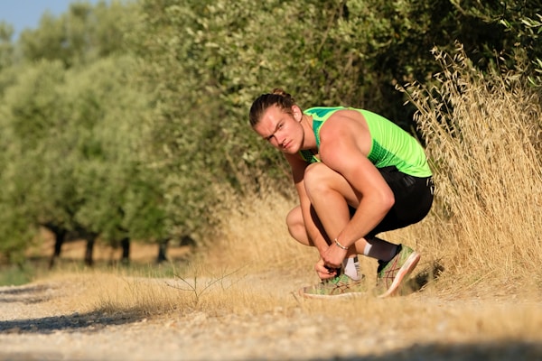 A person adjusting a lightweight knee brace with breathable mesh, ready for a run in the park.