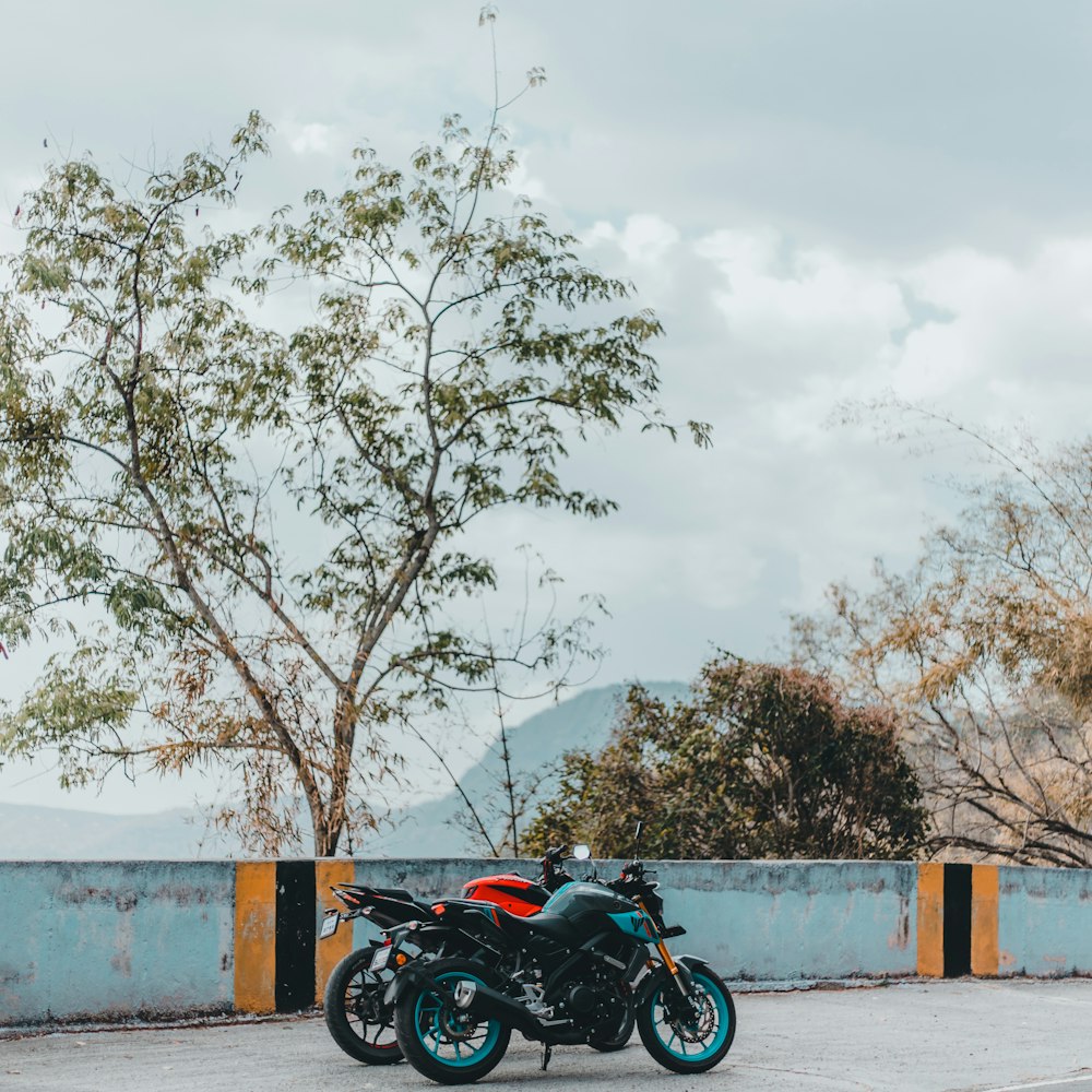 a motorcycle parked in a parking lot next to a tree