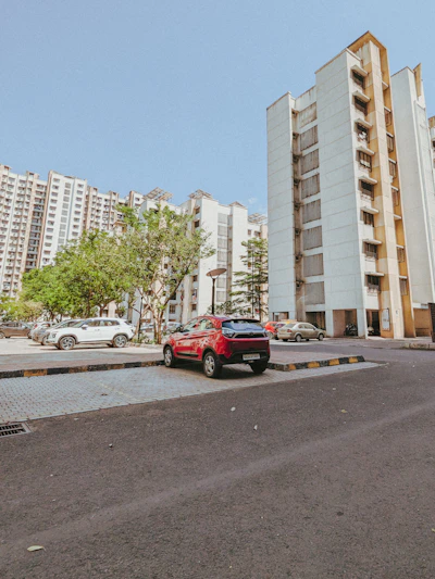 a red car parked in front of a tall building