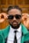 a man wearing sunglasses and a green jacket