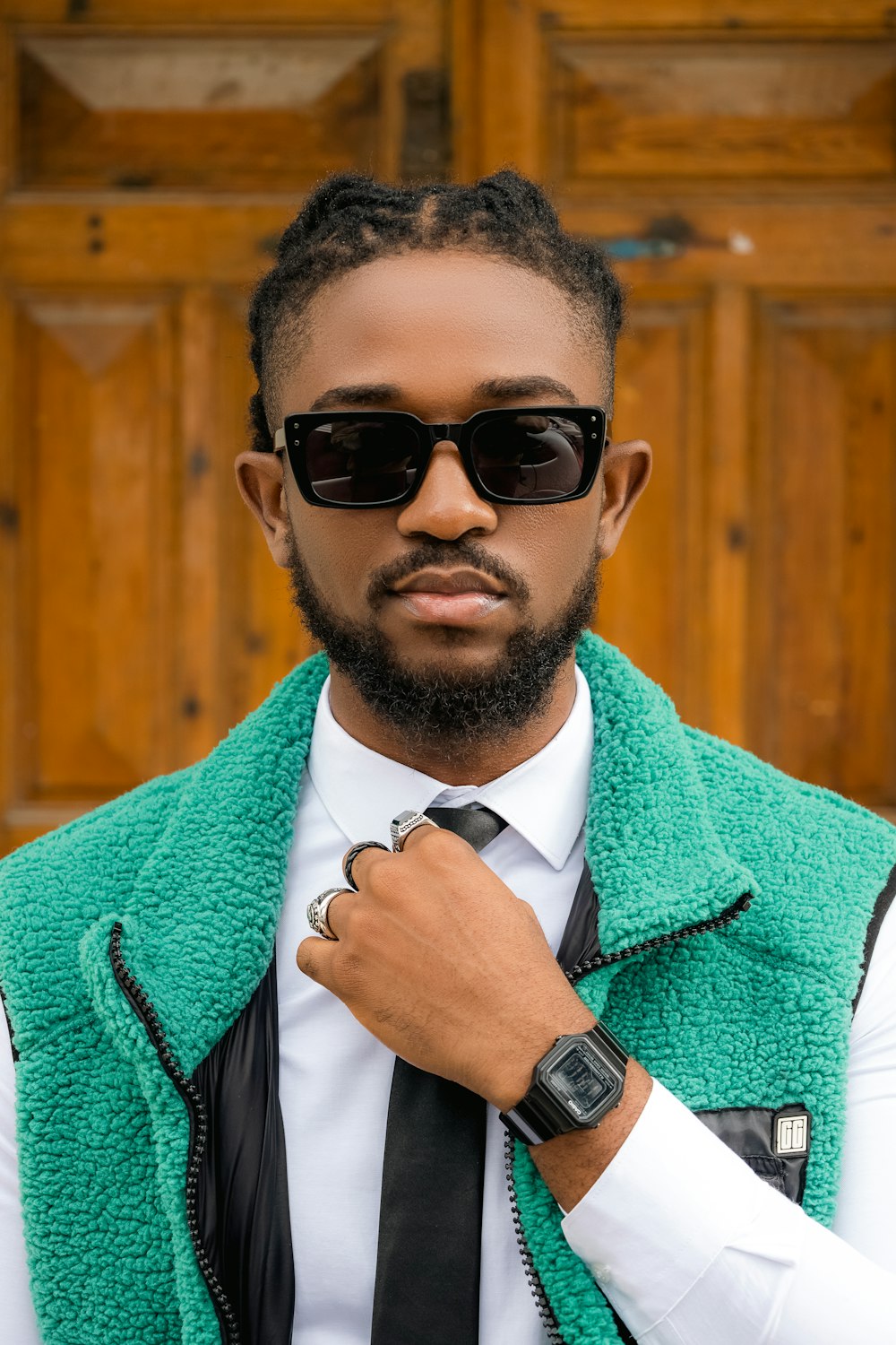 a man wearing a green vest and black tie