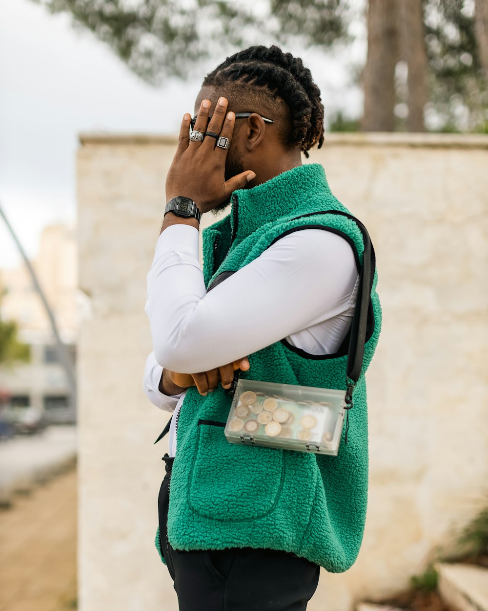 a woman in a green vest talking on a cell phone