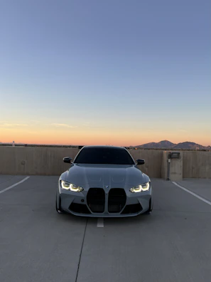 Tesla Model X parked against a glowing Phoenix skyline at dusk.