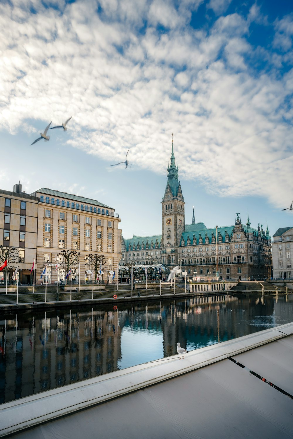 a large building with a clock tower next to a body of water