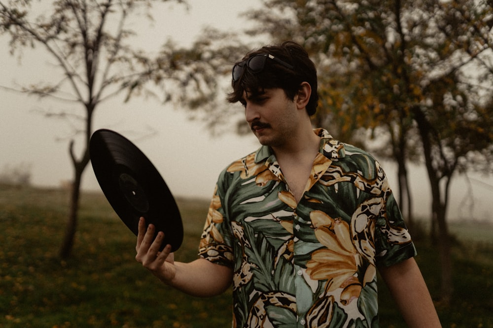 a man in a hawaiian shirt holding a frisbee