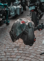 A close-up of a rugged motorcycle helmet resting on a black leather jacket with the tru ikonz patch visible.