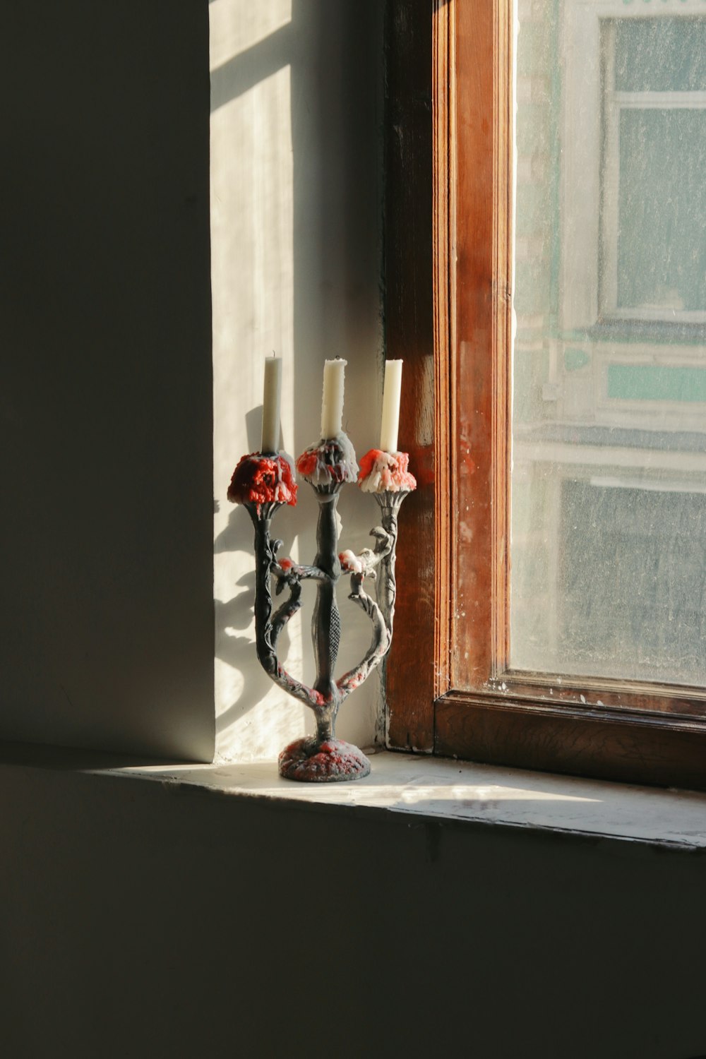 a candle holder sitting on top of a window sill