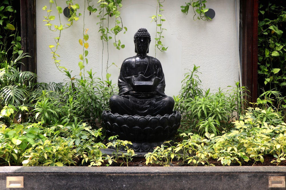 a buddha statue sitting in the middle of a garden