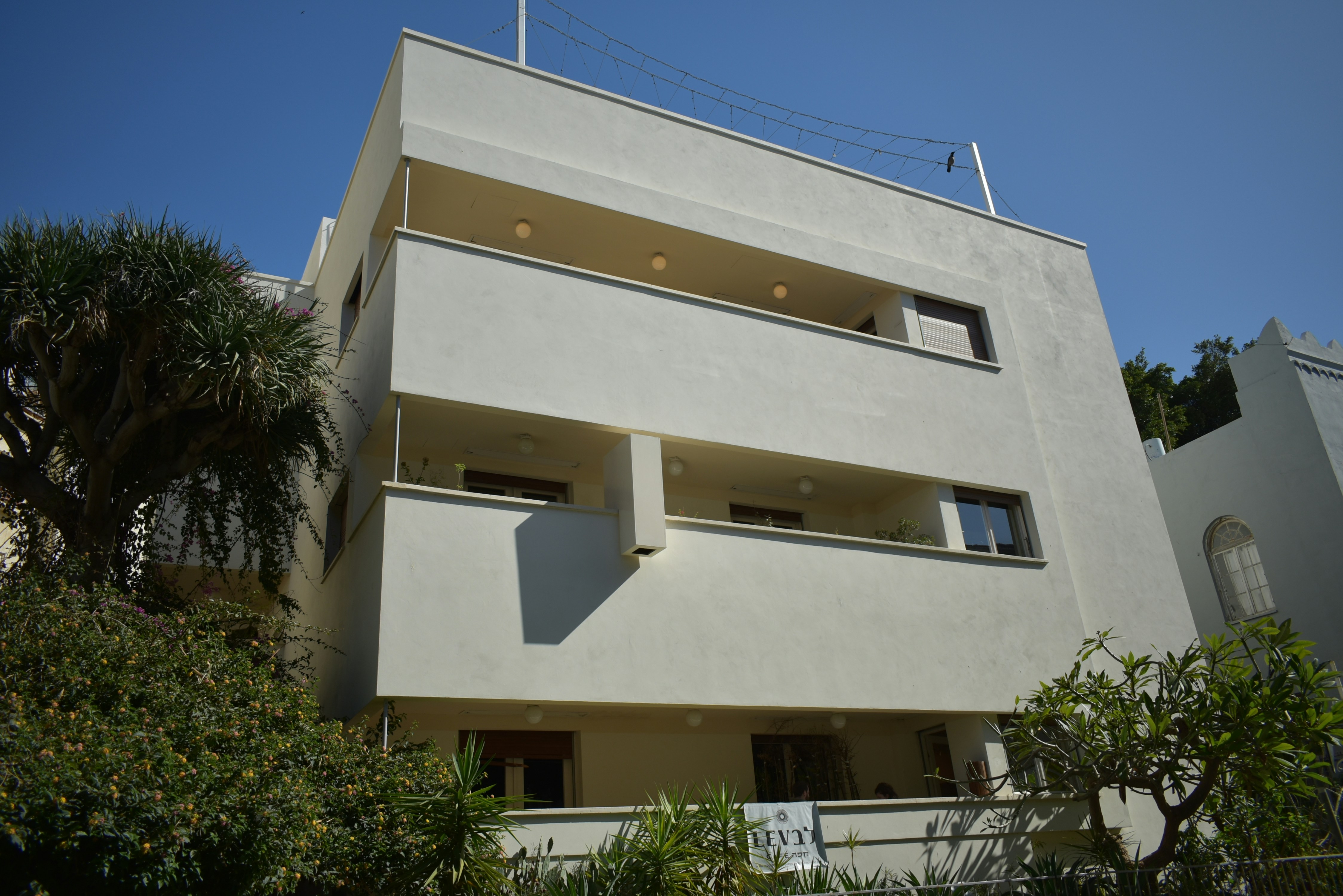 a tall white building with balconies and balconies