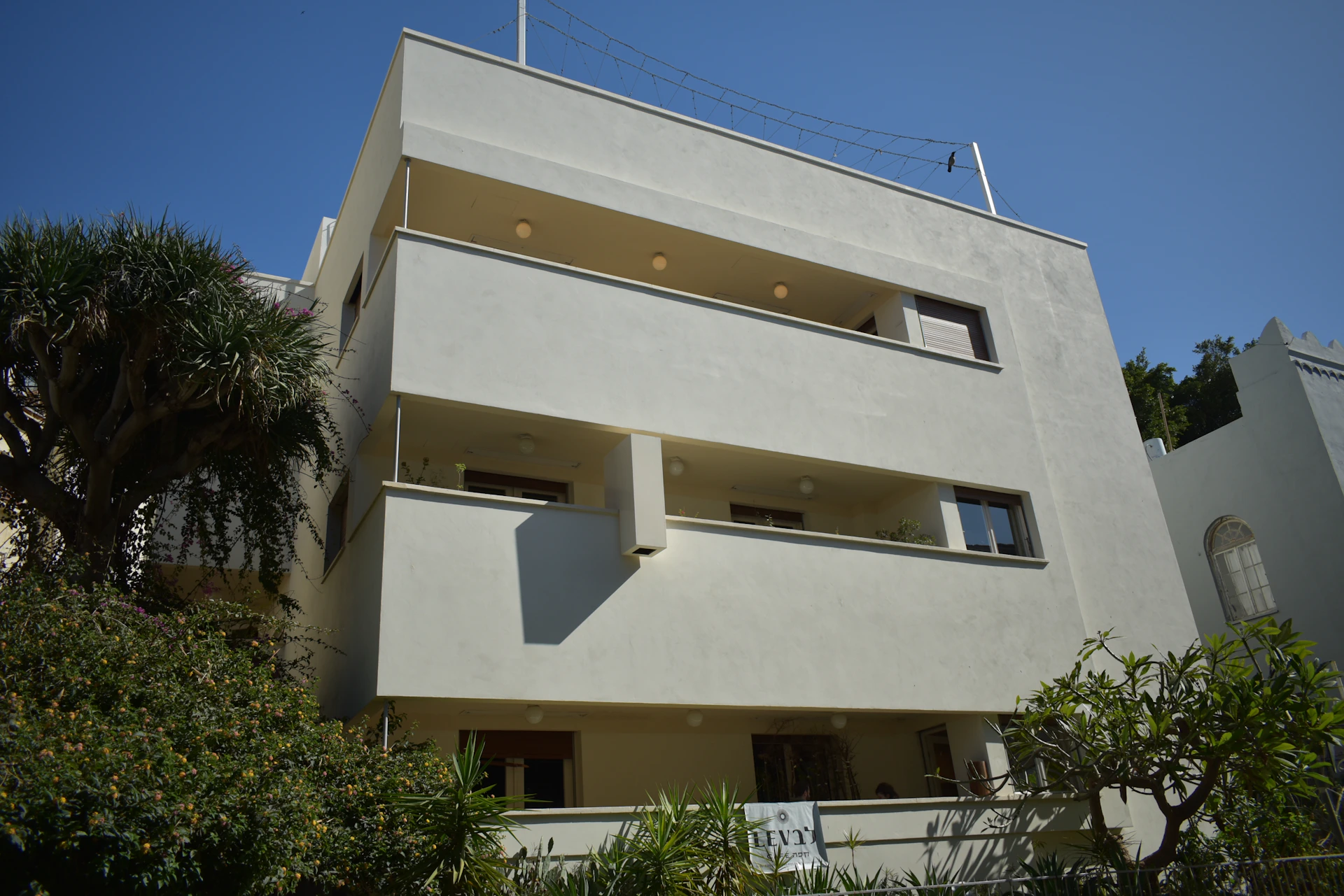 a tall white building with balconies and balconies