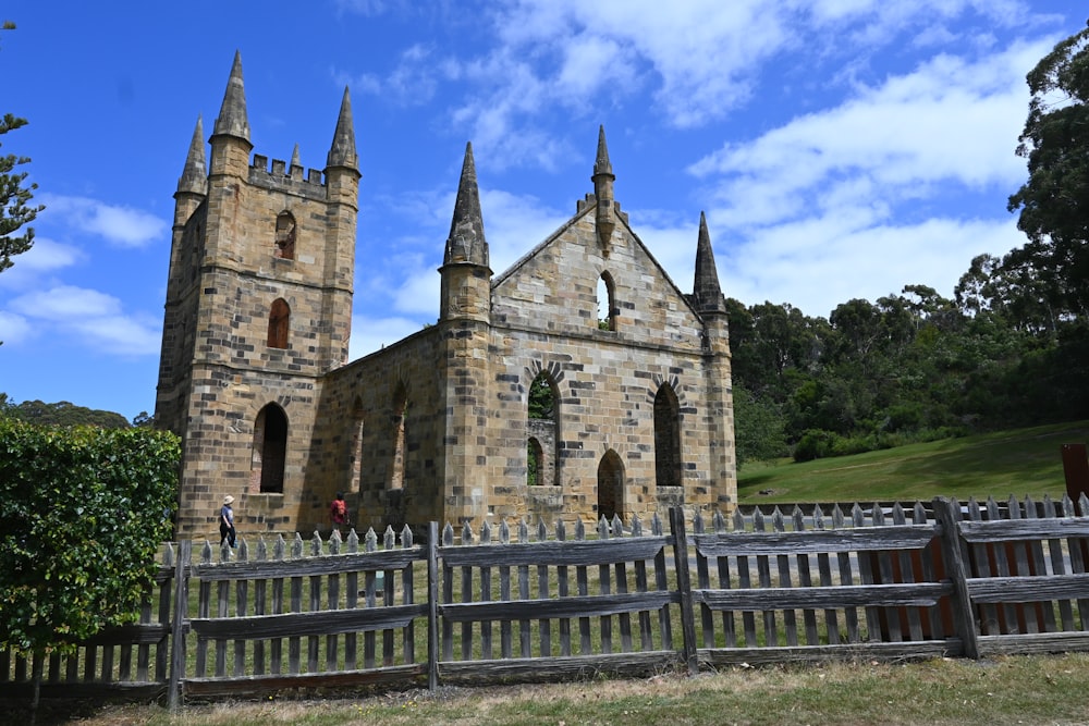 an old church with a wooden fence in front of it