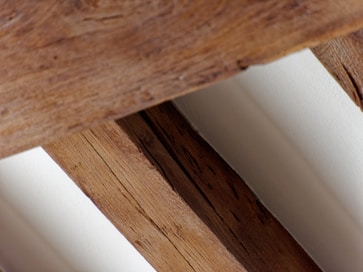 a close up of a wooden bench with white walls