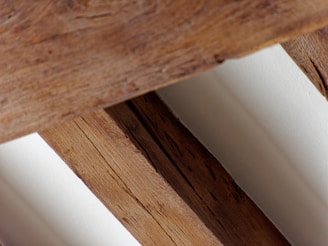 a close up of a wooden bench with white walls