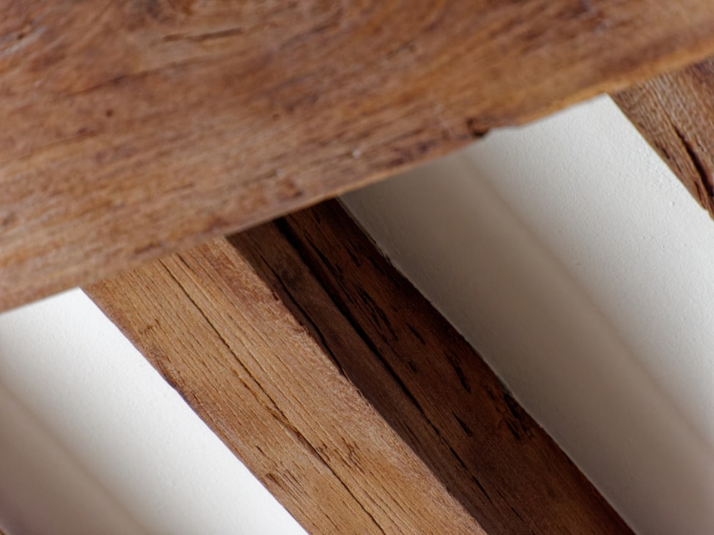 a close up of a wooden bench with white walls