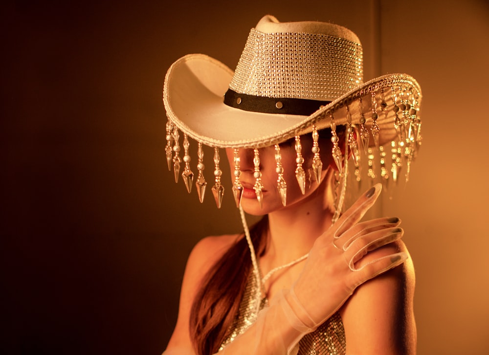 a woman wearing a cowboy hat with chains on it
