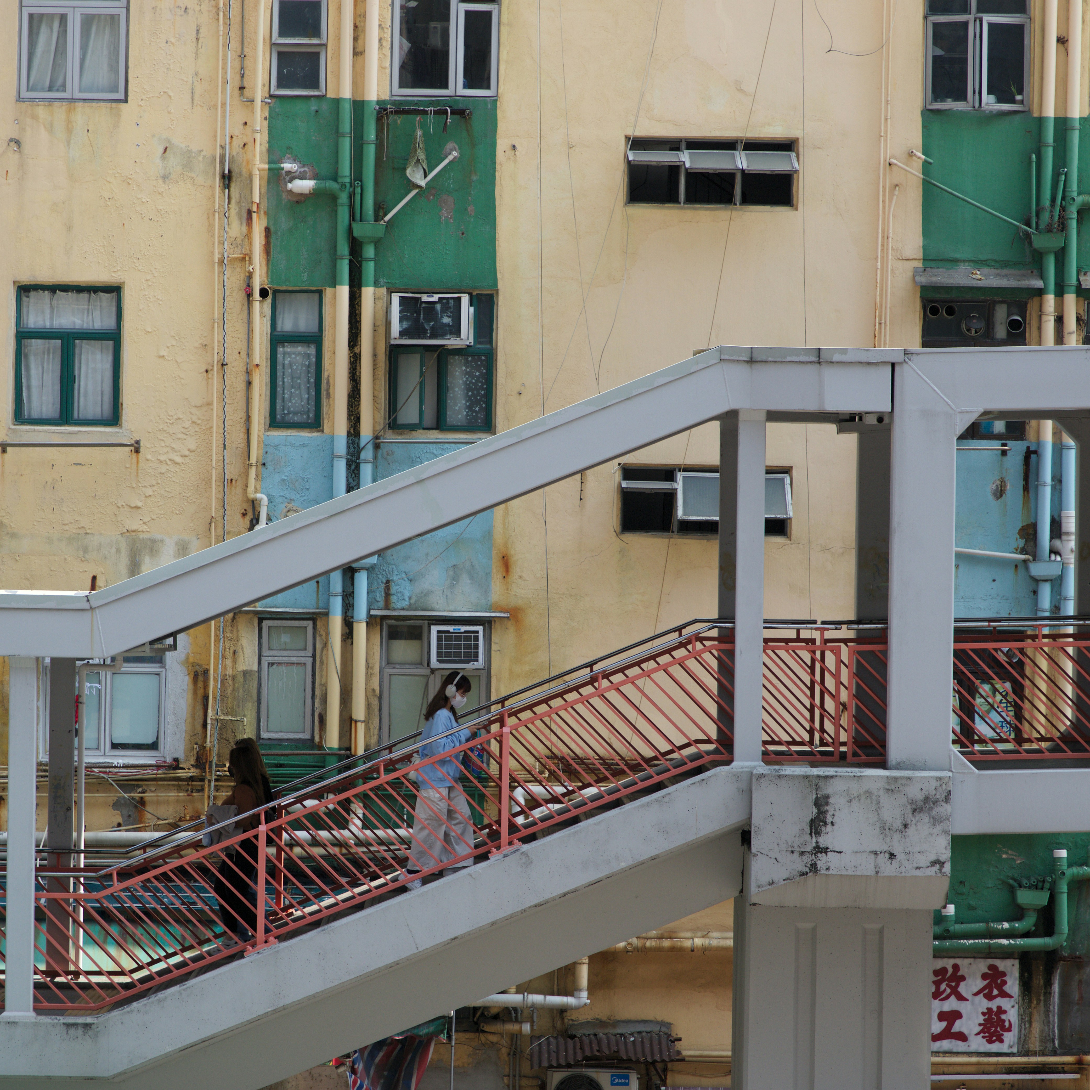 a person walking down a metal staircase in front of a building
