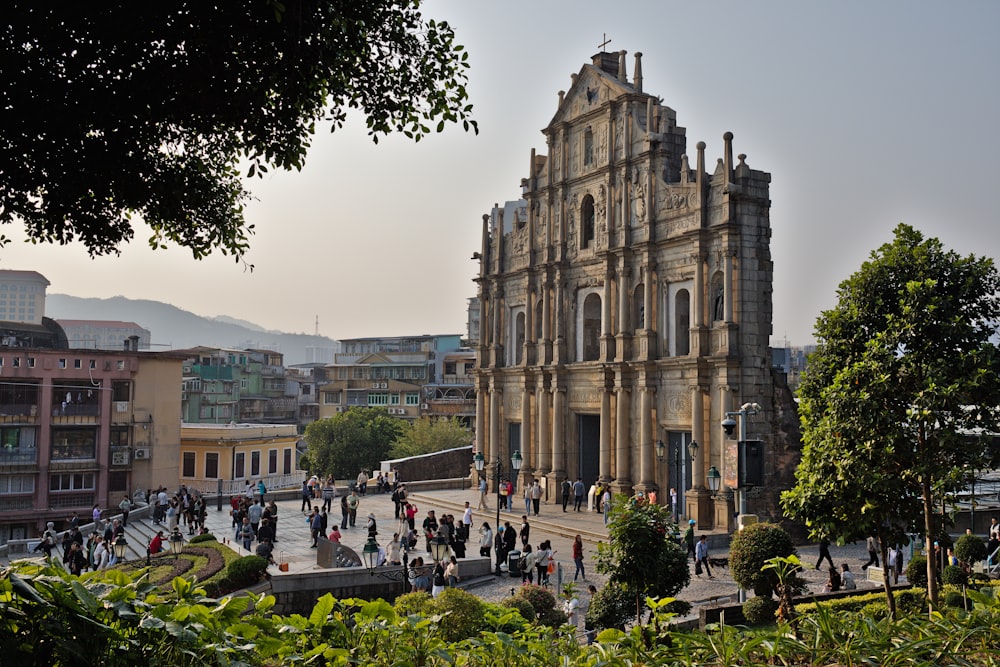 a group of people walking around a large building