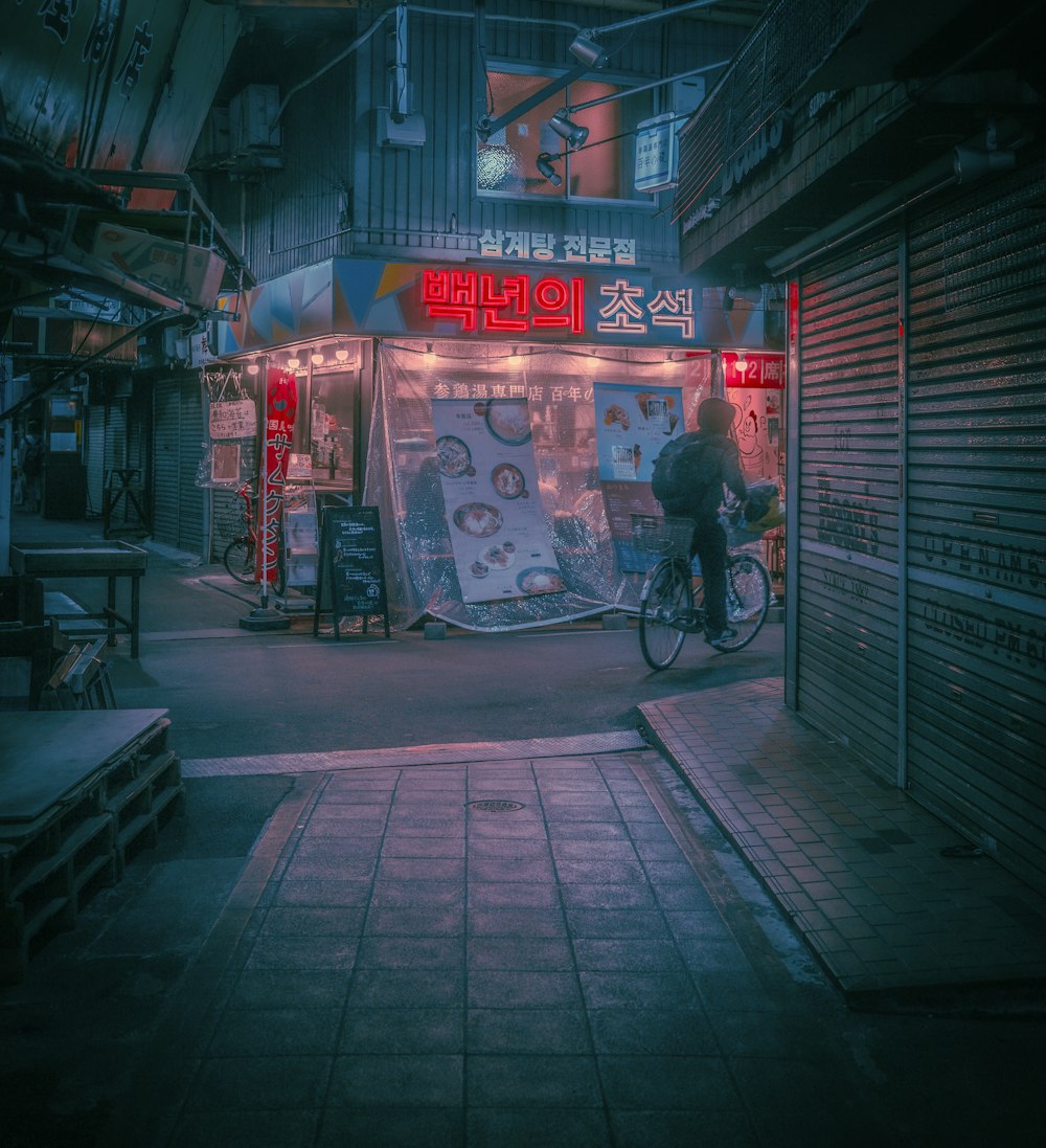 a man riding a bike down a street at night