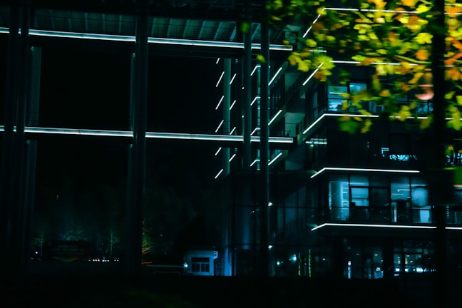 Evening view of a sustainable building project illuminated, highlighting natural materials.