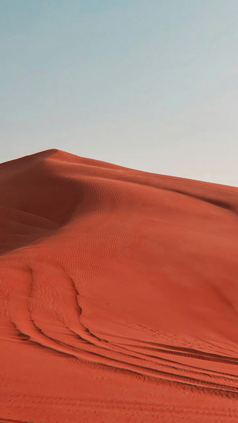 uma pessoa andando através de um grande deserto vermelho