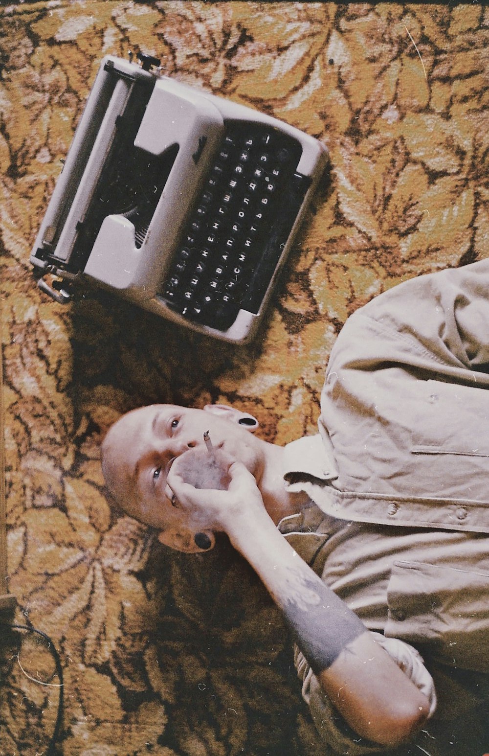 a man laying on the floor next to a computer keyboard