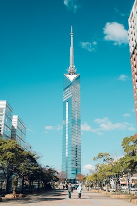a tall skyscraper towering over a city next to tall buildings