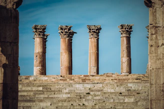 a row of stone pillars in front of a blue sky