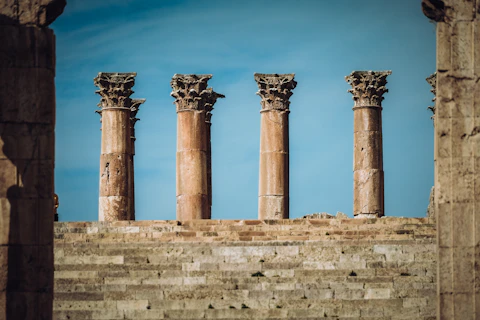 a row of stone pillars in front of a blue sky