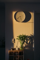 A wall clock showing 3 PM with sunlight streaming in.