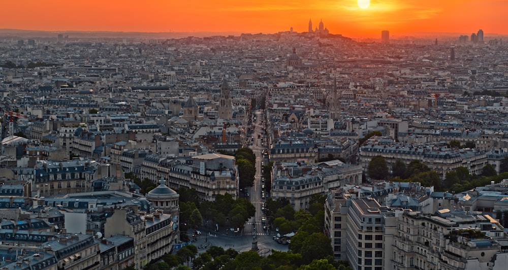 the sun is setting over the city of paris