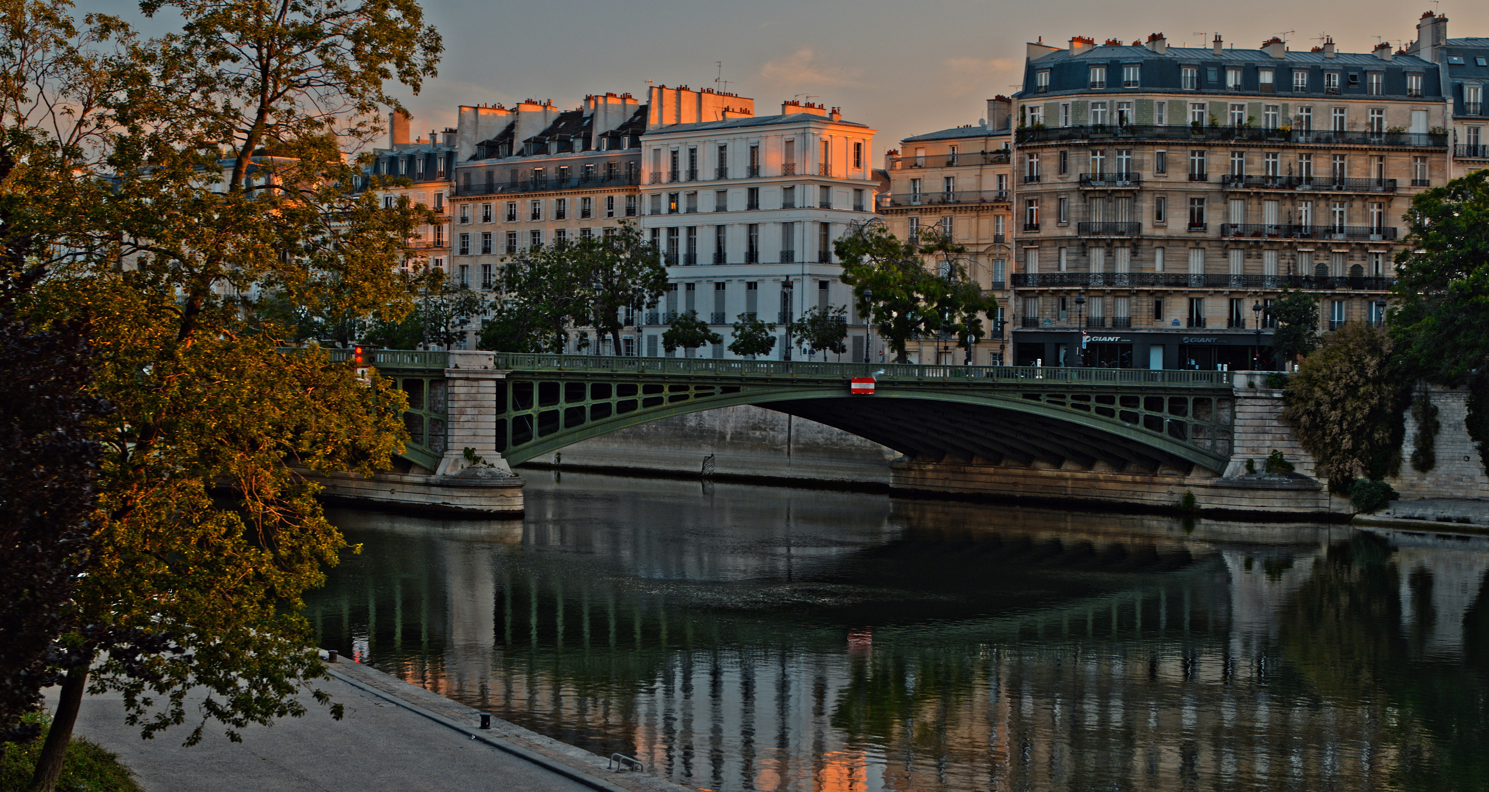 a bridge over a body of water with buildings in the background