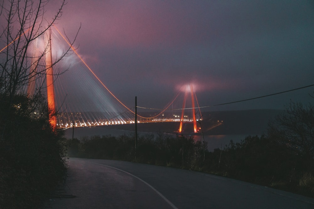 a road with a bridge in the background at night