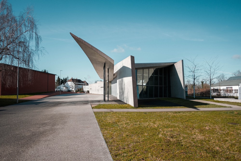 a building with a triangular roof on the side of a road