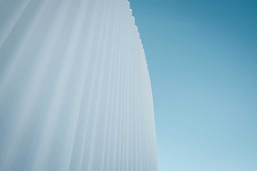 a tall white building with a blue sky in the background