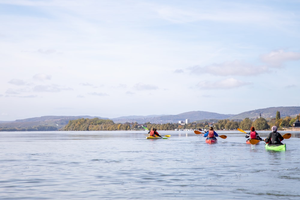 a group of people riding kayaks on top of a lake
