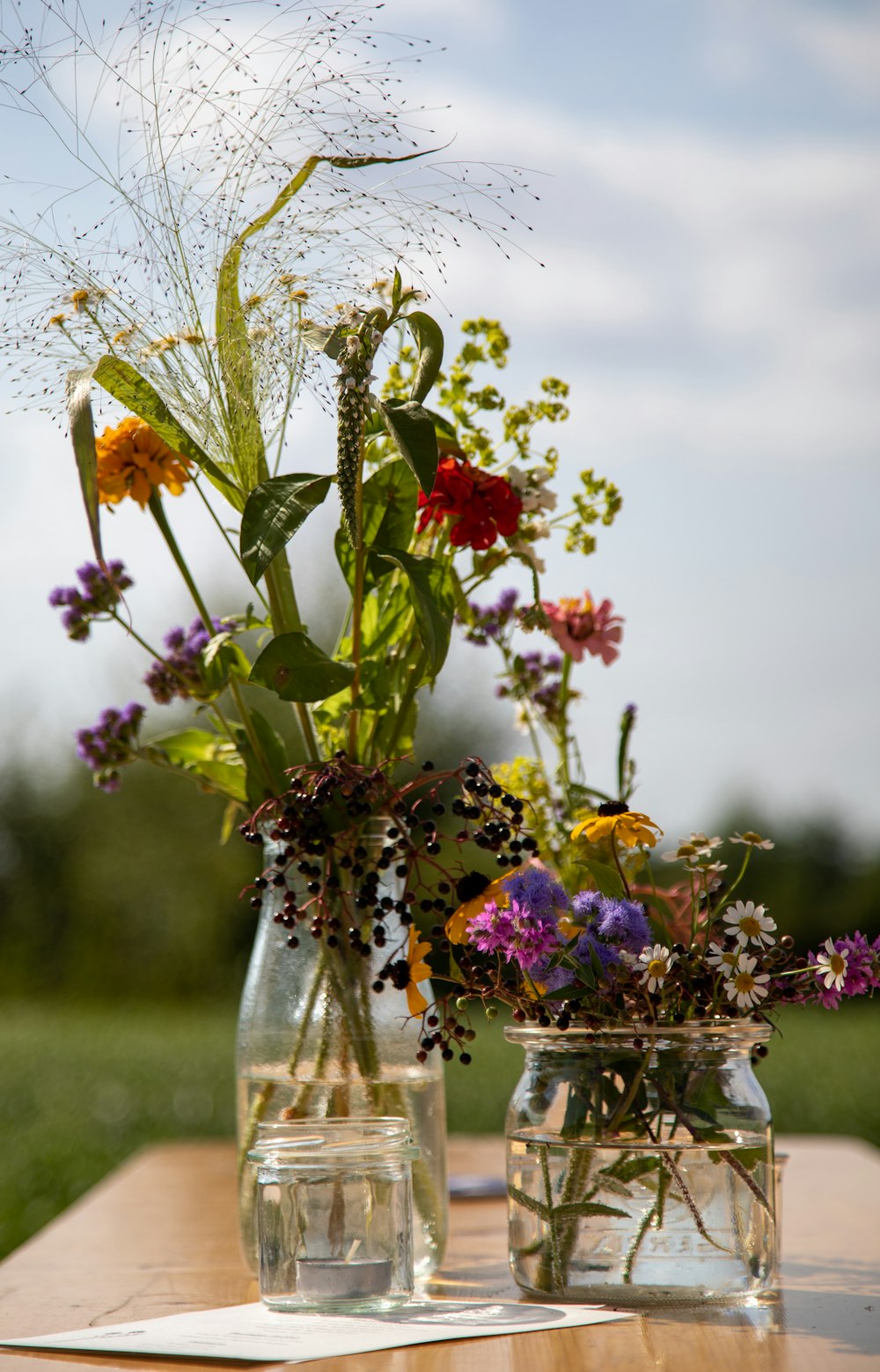 a couple of vases filled with flowers on top of a table