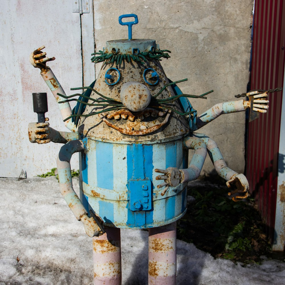 Una estatua de robot azul y blanco con brazos y piernas