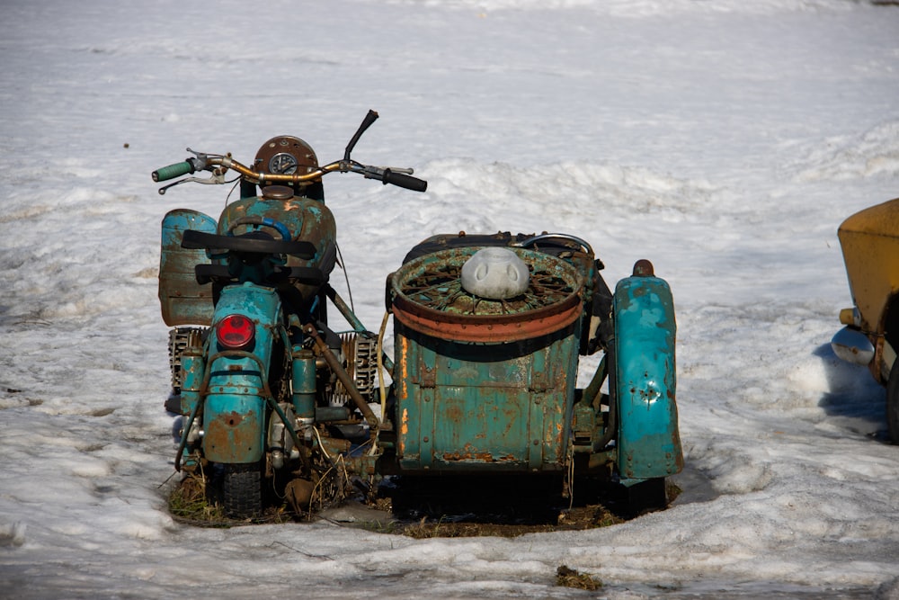 a blue motorcycle parked on top of snow covered ground