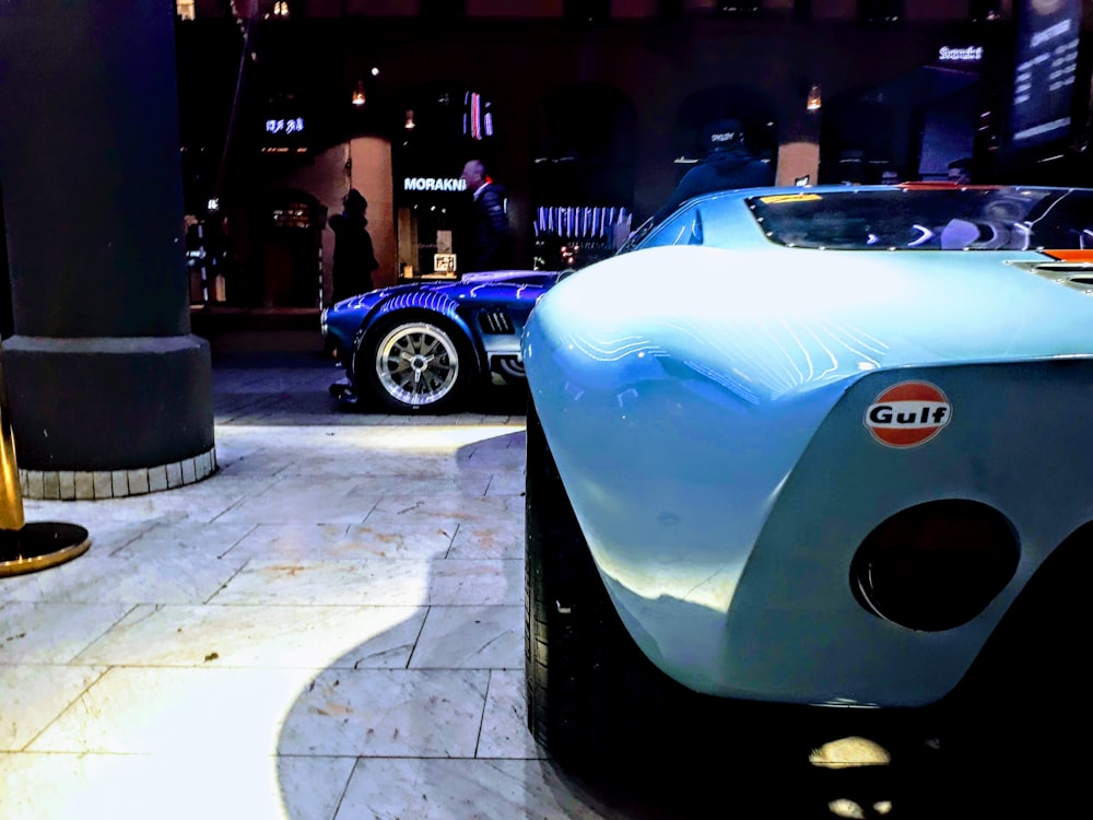 a blue sports car parked next to another blue sports car