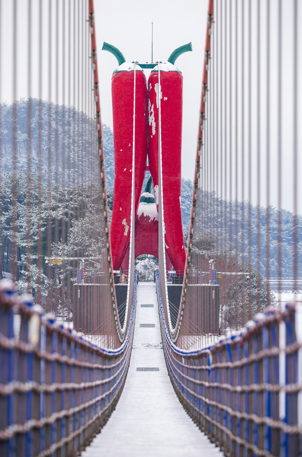 a very tall red object on a bridge