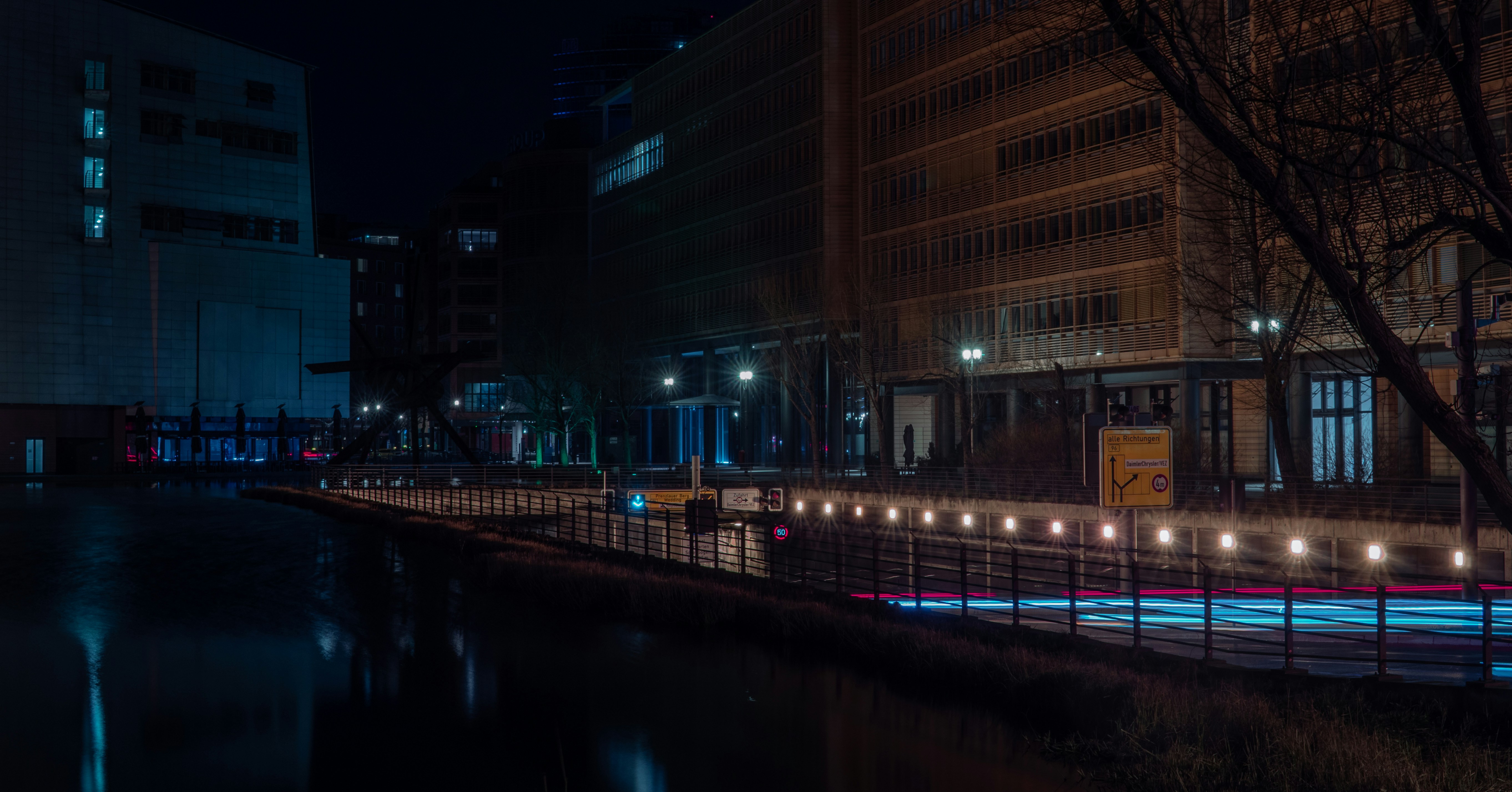 a city street at night with lights reflecting in the water