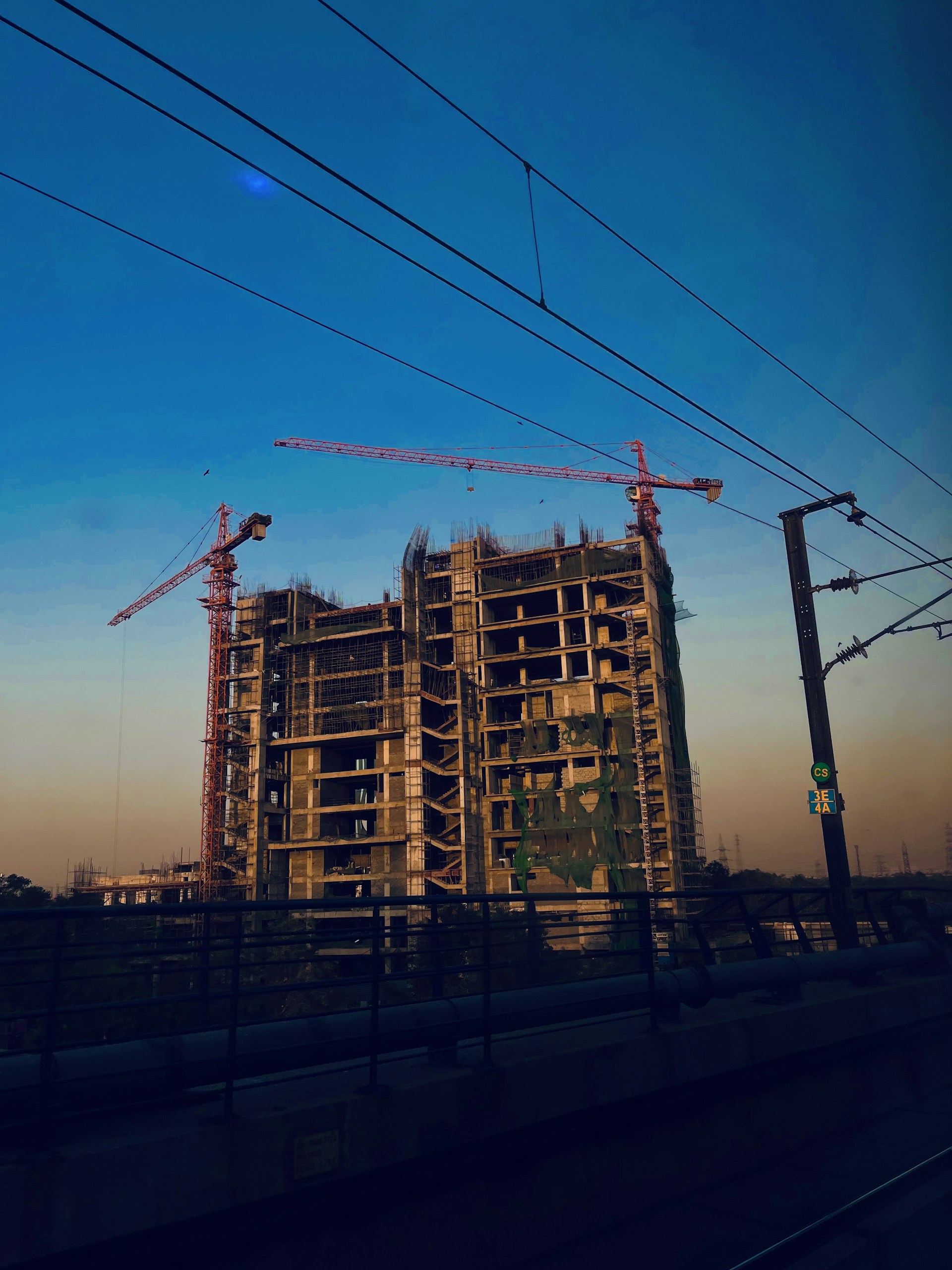 a building under construction with a train passing by