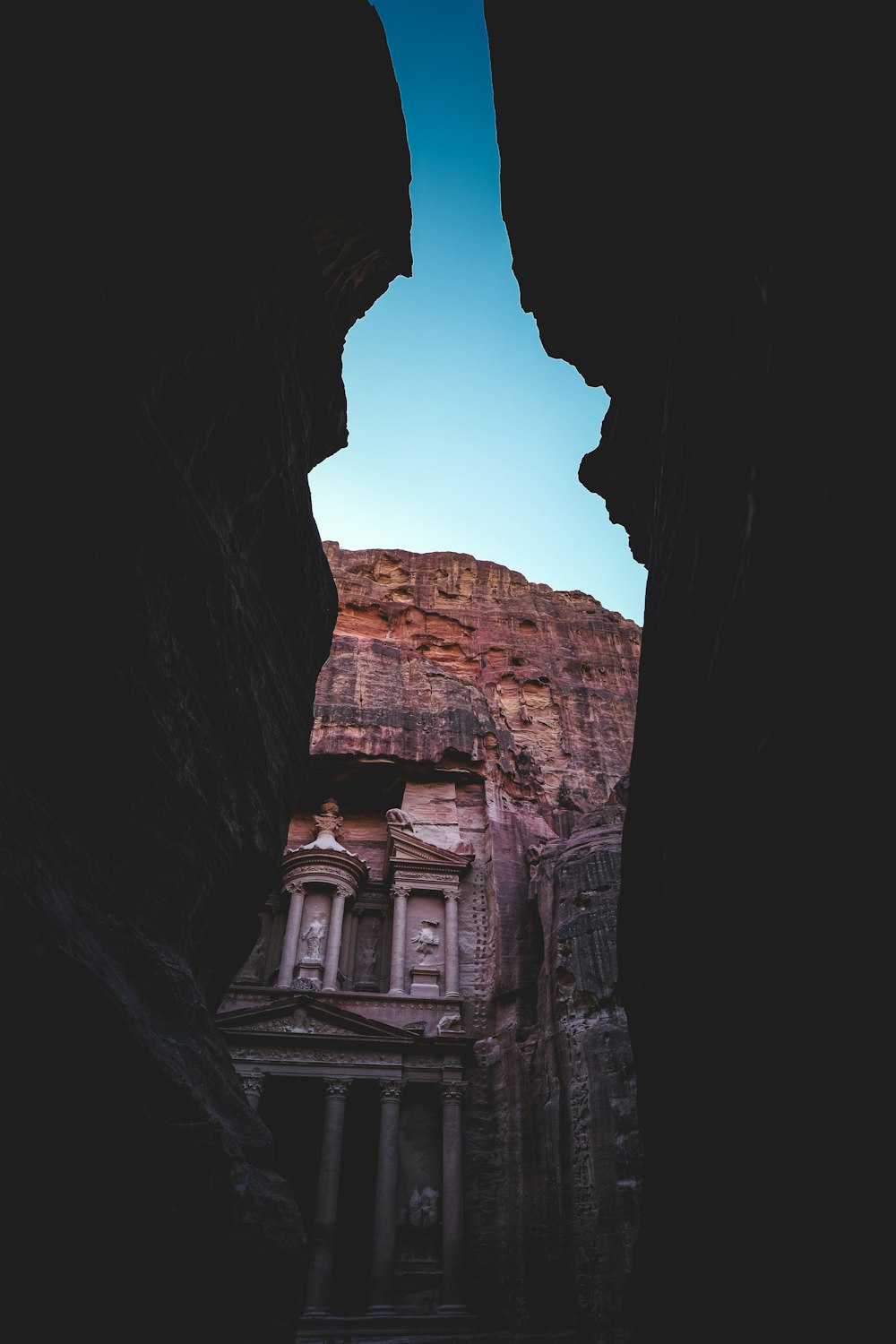 a view of a building through some rocks